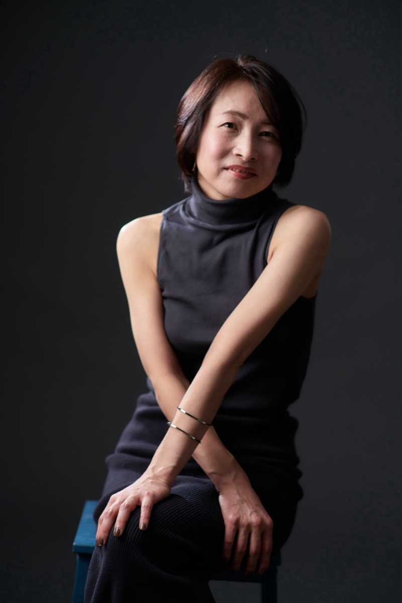 黒い背景で椅子に座る美佳